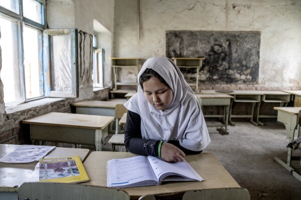 FILE - A girl reads a book in her classroom on the first day of the new school year, in Kabul, Saturday, March 25, 2023. Afghanistan’s schools open Wednesday for the new educational year, while thousands of schoolgirls remain barred from attending classes for the third year as Taliban banned girls from school beyond sixth grade. The Taliban stopped girls’ education beyond sixth grade because they said it didn’t comply with their interpretation of Islamic law, or Sharia. (AP Photo/Ebrahim Noroozi, File)