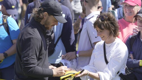 England's Tommy Fleetwood signs autographs on the 12th tee during a practice round for the British Open Golf Championships at the Royal Liverpool Golf Club in Hoylake, England, Wednesday, July 19, 2023. The Open starts Thursday, July 20. (AP Photo/Kin Cheung)