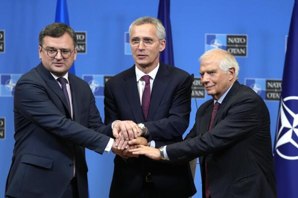From left, Ukraine's Foreign Minister Dmytro Kuleba, NATO Secretary General Jens Stoltenberg and European Union foreign policy chief Josep Borrell join hands after addressing a media conference at NATO headquarters in Brussels, Tuesday, Feb. 21, 2023. (AP Photo/Virginia Mayo)