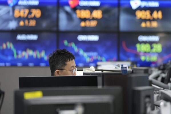 FILE - A currency trader watches monitors at the foreign exchange dealing room of the KEB Hana Bank headquarters in Seoul, South Korea, on Aug. 3, 2023. Asian shares mostly fell Wednesday, Aug. 9 after worries about the U.S. banking system set off a decline on Wall Street and amid concerns closer to home about Chinese economic growth. (AP Photo/Ahn Young-joon, File)