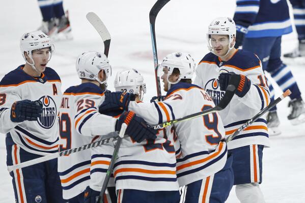 Edmonton Oilers' Zach Hyman (18) celebrates his goal against the Winnipeg Jets with teammates Ryan Nugent-Hopkins (93), Leon Draisaitl (29), Tyson Barrie (22), and Connor McDavid (97)  during the first period of an NHL hockey game in Winnipeg, Manitoba, Saturday, Feb. 19, 2022. (John Woods/The Canadian Press via AP)