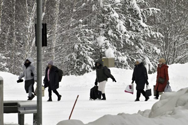 Migrants arrive to Vaalimaa border check point between Finland and Russia in Virolahti, Finland, Friday, Dec. 15, 2023. Finland’s government has decided to seal again, effective Friday, the Nordic country’s entire eastern frontier due to a continuing influx of migrants at the two crossing points on the border with Russia that were reopened on a temporary basis early Thursday. (Heikki Saukkomaa/Lehtikuva via AP)