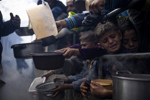 FILE - Palestinians line up for a meal in Rafah, Gaza Strip, Feb. 16, 2024. (AP Photo/Fatima Shbair, File)