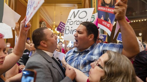 FILE - Pastor Michael Shover of Christ the Redeemer Church in Pella, left, argues with Ryan Maher, of Des Moines, as protestors voice opposition to a new ban on abortion after roughly six weeks of pregnancy introduced by Republican lawmakers in a special session in Des Moines, Iowa, on July 11, 2023. An Iowa judge on Friday, July 14, will consider a request to postpone the state’s new ban on most abortions, just as Gov. Kim Reynolds is scheduled to sign the measure into law in front of 2,000 conservative Christians barely a mile away. (Zach Boyden-Holmes/The Des Moines Register via AP, File)