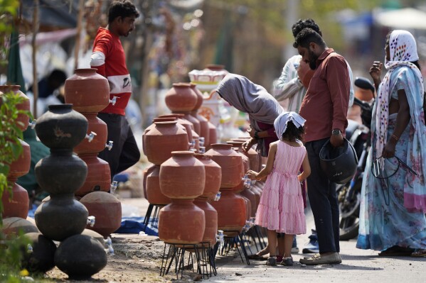 People shop for earthen water vessels, known locally as poor man's refrigerator, from a roadside vendor in Hyderabad, India, Thursday, May 2, 2024. (Ǻ Photo/Mahesh Kumar A.)