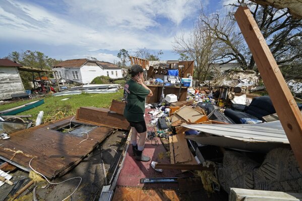 Nicole Beard searches for belongings in the debris of what was the trailer home where she lived in Hackberry, La., in the aftermath of Hurricane Laura, Saturday, Aug. 29, 2020. (AP Photo/Gerald Herbert)