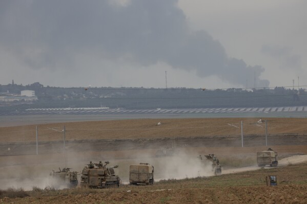 Israeli army vehicles move near the Israeli Gaza border, southern Israel, Monday, Oct. 9, 2023. The militant Hamas rulers of the Gaza Strip carried out an unprecedented, multi-front attack on Israel at daybreak Saturday, firing thousands of rockets as dozens of Hamas fighters infiltrated the heavily fortified border in several locations, killing hundreds and taking captives. Palestinian health officials reported scores of deaths from Israeli airstrikes in Gaza. (AP Photo/Oren Ziv)