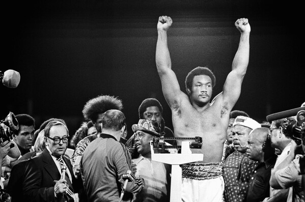 Heavyweight champion George Foreman responds to cheers of crowd in stadium in Kinshasa, Zaire Saturday night, October 26, 1974 during the weigh in for his title defense against Muhammad Ali. (AP Photo, File)