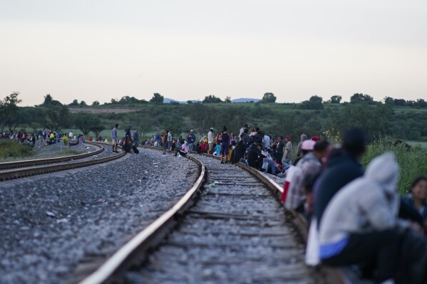 Migrantes esperan a lo largo de las vías con la esperanza de subir a un tren de carga con dirección al norte, uno que se detenga el tiempo suficiente para que puedan subirse, el 19 de septiembre de 2023, en Huehuetoca, México. (AP Foto/Eduardo Verdugo)