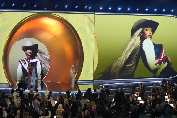 Beyonce accepts the award for best country album for "COWBOY CARTER" during the 67th annual Grammy Awards on Sunday, Feb. 2, 2025, in Los Angeles. Taylor Swift looks on from left. (AP Photo/Chris Pizzello)