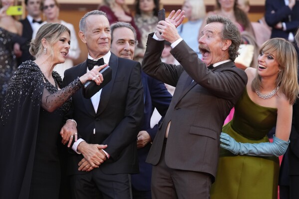 Rita Wilson, from left, Tom Hanks, composer Alexandre Desplat, Bryan Cranston and Maya Hawke pose for photographers upon arrival at the premiere of the film 'Asteroid City' at the 76th international film festival, Cannes, southern France, Tuesday, May 23, 2023. (Photo by Scott Garfitt/Invision/AP)