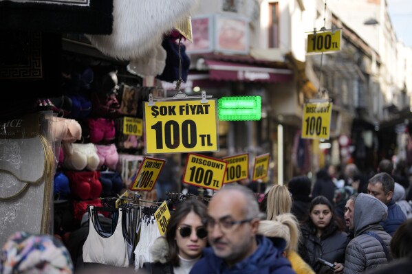 Prices are displayed in a clothes shop at Eminonu commercial area in Istanbul, Turkey, Wednesday, Feb. 21, 2024. Turkey's central bank left its key interest rate unchanged at 45% on Thursday, pausing a series of aggressive rate hikes aimed at taming high inflation. (APPhoto/Khalil Hamra)