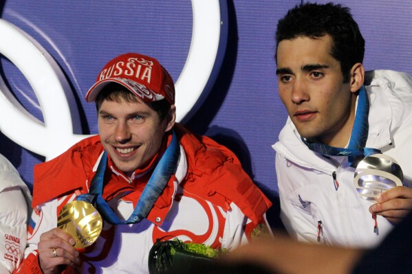 Russia's gold medal winner Evgeny Ustyugov, left, and France's silver medal winner Martin Fourcade, pose for photos during their medal ceremony for the Men's 15k mass start Biathlon race at the Vancouver 2010 Olympics in Whistler, British Columbia, Canada, Feb. 21, 2010. (AP Photo/Dmitry Lovetsky, File)