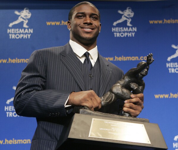 FILE - Heisman Trophy winner Reggie Bush of the University of Southern California smiles while posing for photos after a news conference in New York, Dec. 10, 2005. Reggie Bush has been reinstated as the 2005 Heisman Trophy winner, Wednesday, April 24, 2024, more than a decade after Southern California returned the award following an NCAA investigation that found he received what were impermissible benefits during his time with the Trojans.(AP Photo/Frank Franklin II, File)