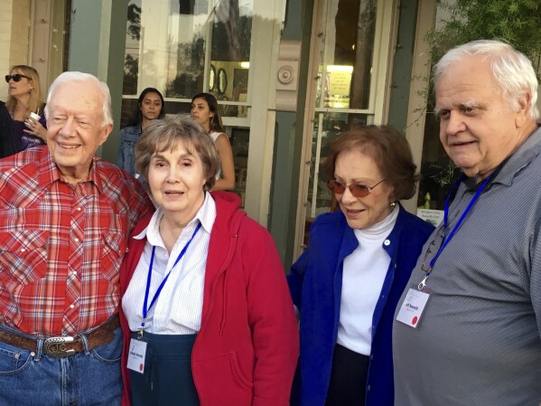 This April 2016 photo provided by Terry Adamson shows Achsah Nesmith, second from left, and her husband, Jeff Nesmith, right, posing for a photo with former President Jimmy Carter and his wife, Rosalynn Carter, in Plains, Ga. Achsah Nesmith, a speechwriter for Carter during his presidency, died March 5, 2025, in Alexandria, Va. (Terry Adamson via AP)