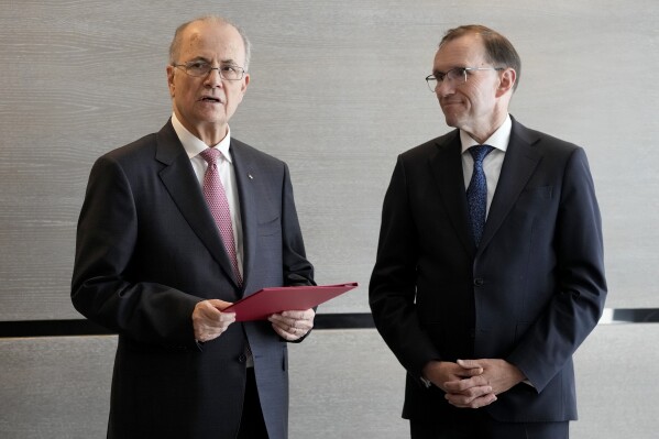 Prime Minister of the Palestinian Authority Mohammed Mustafa, left, speaks after receiving a document handed over by Norway's Foreign Minister Espen Barth Eide, right, prior to a meeting for talks on the Middle East in Brussels, Sunday, May 26, 2024. Norway on Sunday handed over papers to the Palestinian prime minister to officially give it diplomatic recognition as a state in a largely symbolic move that has infuriated Israel. The formal recognition by Norway, Spain and Ireland, which all have a record of friendly ties with both the Israelis and the Palestinians, while long advocating for a Palestinian state, is planned for Tuesday. (AP Photo/Virginia Mayo)
