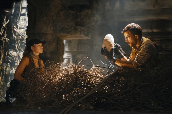 This image released by Universal Pictures and Amblin Entertainment shows Scarlett Johansson, left, and Jonathan Bailey in a scene from " Jurassic World Rebirth." (Jasin Boland/Universal Pictures and Amblin Entertainment via AP)