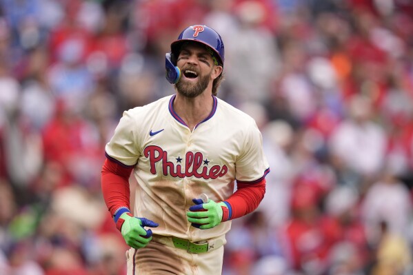Philadelphia Phillies' Bryce Harper reacts after hitting an RBI-sacrifice flay against Chicago White Sox pitcher Tanner Banks during the fourth inning of a baseball game, Sunday, April 21, 2024, in Philadelphia. (AP Photo/Matt Slocum)