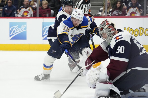 St. Louis Blues left wing Jakub Vrana, center, shoots on Colorado Avalanche goaltender Ivan Prosvetov, who stops the shot during the second period of an NHL hockey game Wednesday, Nov. 1, 2023, in Denver. At rear is Avalanche defenseman Cale Makar. (AP Photo/David Zalubowski)