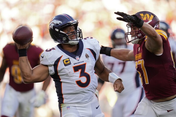 Denver Broncos quarterback Russell Wilson (3) tries to get a pass away as he is pressured by Washington Commanders linebacker Cody Barton (57) in the second half of an NFL football game Sunday, Sept. 17, 2023, in Denver. (AP Photo/Jack Dempsey)