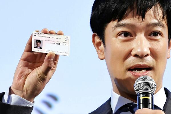 Japanese actor Masato Sakai shows a sample of My Number card during a promotional event in Tokyo on March 8, 2021. Japan has stepped up its push to catch up on digitization by telling a reluctant public they have to sign up for digital IDs or possibly lose access to their public health insurance. (Kyodo News via AP)