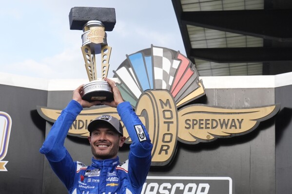 Kyle Larson holds the trophy after winning a NASCAR Cup Series auto race at Indianapolis Motor Speedway, Sunday, July 21, 2024, in Indianapolis. (ĢӰԺ Photo/Darron Cummings)