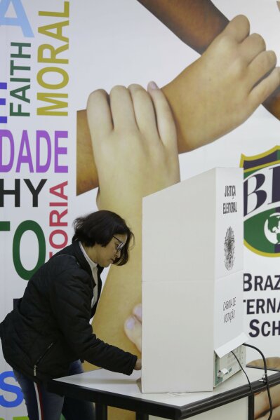 
              A woman casts her vote in the general elections in Sao Paulo, Brazil, Sunday, Oct. 7, 2018. Brazilians have started trickling to voting booths to choose leaders in an election marked by intense anger at the ruling class following years of political and economic turmoil. (AP Photo/Nelson Antoine)
            