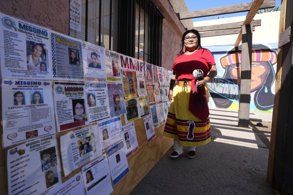 Grassroots advocate Reva Stewart walks outside the headquarters at Drumbeat Indian Arts, Monday, July 31, 2023, in Phoenix. Stewart and the women working with her are trying to help find lost Native Americans who were left without a place to stay after the phony treatment centers in the Phoenix area abruptly shut down when Arizona cut off their Medicaid money amid investigations into widespread fraudulent billing. (AP Photo/Ross D. Franklin)