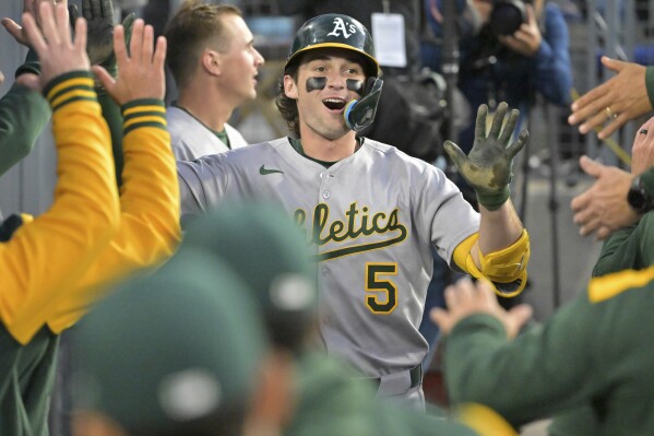 Athletics Jacob Wilson is congratulated in the dugout after hitting a 3-run home run during the third inning of a baseball game against the Los Angeles Dodgers, May 13, 2025, in Los Angeles. (AP Photo/Jayne Kamin-Oncea)