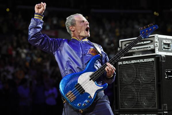 FILE - In this April 13, 2014 file photo, Flea, bassist for the Red Hot Chili Peppers, plays the national anthem prior to an NBA basketball game between the Los Angeles Lakers and the Memphis Grizzlies in Los Angeles. Flea turned 59 on Saturday, Oct. 16, 2021, and his Silverlake Conservatory of Music turned 20, and they celebrated with a joint party in the parking lot for the Los Angeles school that often serves as a de facto performance space for its faculty and students. (AP Photo/Mark J. Terrill, File)