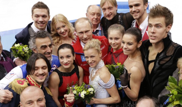 FILE - Russian President Vladimir Putin, center back, poses with the Russian team in the team figure skating competition at the Iceberg Skating Palace during the 2014 Winter Olympics, in Sochi, Russia, on Sunday, Feb. 9, 2014. A subsequent doping scandal tainted the success of the Russian team at the Sochi Games. (AP Photo/David J. Phillip, File)
