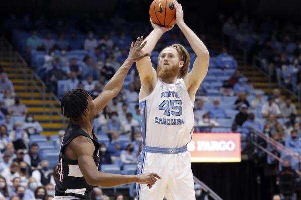 North Carolina's Brady Manek (45) shoots as Louisville's Jae'Lyn Withers, left, defends during the first half of an NCAA college basketball game in Chapel Hill, N.C., Monday, Feb. 21, 2022. (Ethan Hyman/The News & Observer via AP)