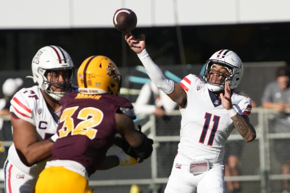 Arizona quarterback Noah Fifita (11) throws downfield against Arizona State in the first half during an NCAA college football game, Saturday, Nov. 25, 2023, in Tempe, Ariz. (AP Photo/Rick Scuteri)