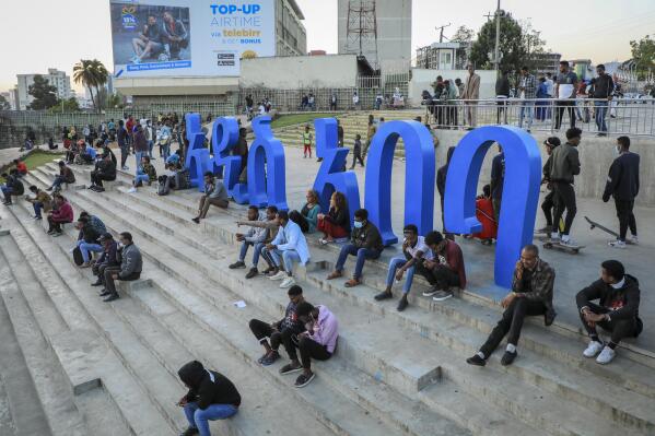 People sit on steps next to a sculpture in the shape of Amharic words reading "Addis Ababa" in the Piazza old town area of the capital Addis Ababa, Ethiopia Thursday, Nov. 4, 2021. Urgent new efforts to calm Ethiopia's escalating war are unfolding Thursday as a U.S. special envoy visits and the president of neighboring Kenya calls for an immediate cease-fire while the country marks a year of conflict. (AP Photo)