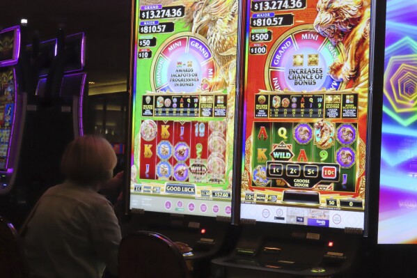 A gambler plays a slot machine at Harrah's casino in Atlantic City, N.J., on Sept. 29, 2023. On Nov. 21, 2023, New Jersey gambling regulators said Atlantic City's casinos and two internet-only entities earned $281.2 million in the third quarter of this year, a decline of 7.5% from the same period a year ago. (AP Photo/Wayne Parry)