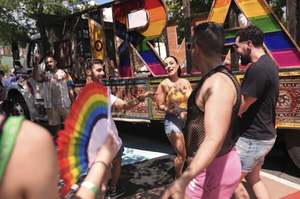 Attendees of Iranian descent Niloofar Jebelli, of Falls Church, Va., from second left, Leila Beig, of Washington, Arash Azma, of Washington, and Adoril Oshana, of San Jose, Calif., dance alongside the Iran pride float during the World Pride parade, Saturday, June 7, 2025, in Washington. (AP Photo/Jacquelyn Martin)