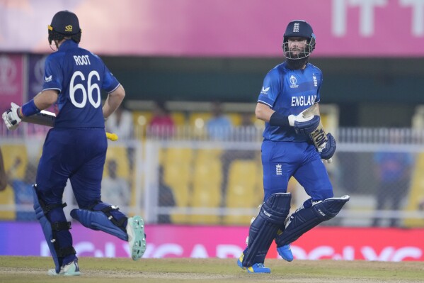 England's Moeen Ali, right, along with Joe Root runs between the wickets to score during the ICC Cricket World Cup warm up match between Bangladesh and England in Guwahati, India, Monday, Oct.2, 2023. (AP Photo/Anupam Nath)