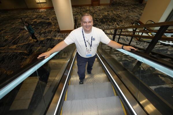 Student resource officer Tony Ramaeker, from Elkhorn, Neb., heads up an escalator while attending a convention, Tuesday, July 5, 2022, in Denver. (AP Photo/David Zalubowski)