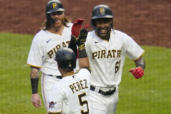FILE - Pittsburgh Pirates' Oneil Cruz (61) celebrates with Ben Gamel, rear, and Michael Perez (5) as he returns to the dugout after hitting a two-run home run, his first in the Major Leagues, off Cincinnati Reds relief pitcher Mychal Givens during the ninth inning of a baseball game in Pittsburgh, Sunday, Oct. 3, 2021. Towering Pirates shortstop Oneil Cruz is hoping to turn last fall's cameo into a full-time job in the major leagues. The 6-foot-7 Cruz is considered a linchpin of Pittsburgh's rebuilding process and he showed flashes of what could be during a late-season call-up last fall. (AP Photo/Gene J. Puskar, File)
