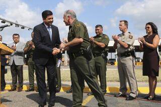 FILE - In this June 7, 2018 file photo, U.S. Border Patrol Sector Chief for the Rio Grande Valley Manuel Padilla Jr., center, shakes hands with Tamaulipas Gov. Francisco Garcia Cabeza de Vaca, during a news conference at the Hidalgo-Reynosa International Bridge in Hidalgo, Texas. Mexico’s congress voted Friday, April 30, 2021, to impeach Garcia Cabeza de Vaca on charges of tax evasion, money laundering and organized crime. (Nathan Lambrecht/The Monitor via AP File)