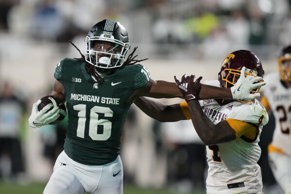 Michigan State wide receiver Christian Fitzpatrick (16) stiff arms Central Michigan defensive back Donte Kent (4) during the second half of an NCAA college football game, Friday, Sept. 1, 2023, in East Lansing, Mich. (AP Photo/Carlos Osorio)