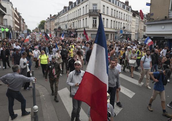Demonstrators march in Lille, northern France, Saturday, Aug. 21, 2021, during a rally against the COVID-19 health pass needed to access restaurants, long-distance trains and other venues. (AP Photo/Michel Spingler)