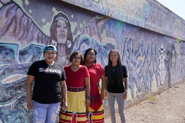 Grassroots advocates Raquel Moody, left, Coleen Chatter, second from left, Reva Stewart, and Geri Long, right, stand outside their headquarters at Drumbeat Indian Arts, Monday, July 31, 2023, in Phoenix. The women are trying to help find lost Native Americans who were left without a place to stay after the phony treatment centers in the Phoenix area abruptly shut down when Arizona cut off their Medicaid money amid investigations into widespread fraudulent billing. (AP Photo/Ross D. Franklin)