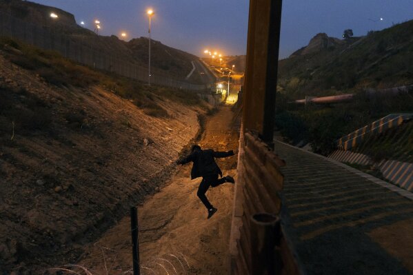 
              FILE - In this Dec. 21, 2018, file photo, a Honduran youth jumps from the U.S. border fence in Tijuana, Mexico.   California's attorney general filed a lawsuit Monday, Feb. 18, 2019, against President Donald Trump's emergency declaration to fund a wall on the U.S.-Mexico border. Xavier Becerra released a statement Monday saying 16 states — including California — allege the Trump administration's action violates the Constitution. (AP Photo/Daniel Ochoa de Olza, File)
            