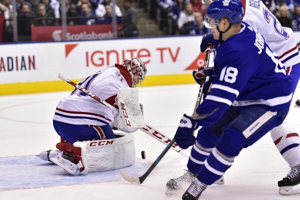 
              Toronto Maple Leafs left wing Andreas Johnsson (18) and Montreal Canadiens defenseman Mike Reilly (28) battle for a rebound as Montreal Canadiens goaltender Carey Price (31) makes the save during first period NHL hockey action in Toronto on Saturday, Feb.23, 2019. (Frank Gunn/The Canadian Press via AP)
            