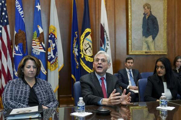 Flanked by U.S. Deputy Attorney General Lisa Monaco, left, and Associate Attorney General Vanita Gupta, Attorney General Merrick Garland speaks during a meeting at the Justice Department, Thursday, March 10, 2022 in Washington. (Kevin Lamarque, Pool via AP)