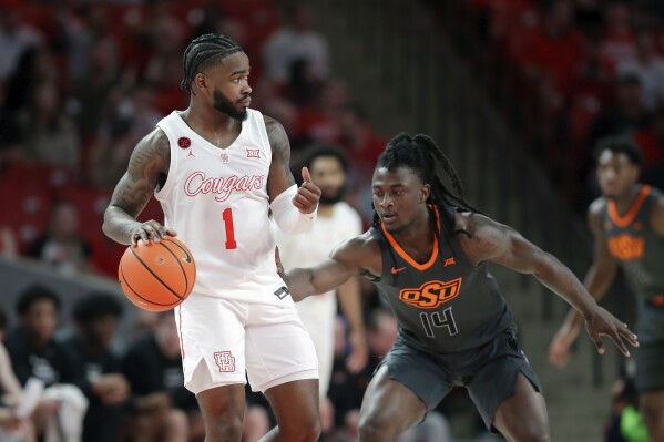 Houston guard Jamal Shead (1) looks for a way around Oklahoma State guard Jamyron Keller (14) during the first half of an NCAA college basketball game Tuesday, Feb. 6, 2024, in Houston. (AP Photo/Michael Wyke)