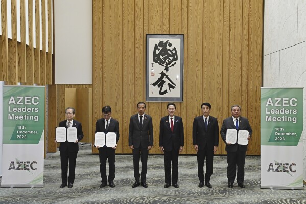 Indonesia's President Joko Widodo, third left, and Japan's Prime Minister Fumio Kishida, fourth left, pose for a photo following the announcement of their joint statement to support meetings of the Asian Zero Energy Carbon (AZEC), at the prime minister's office in Tokyo, Monday, Dec. 18, 2023. The AZEC summit is held in Tokyo in conjunction with the ASEAN-Japan 50th anniversary Commemorative Summit. Other officials are Vice Chairman and Secretary-General of KEIDANREN (Japan Business Federation) Masakazu Kubota, from left, President of the Economic Research Institute for ASEAN and East Asia Tetsuya Watanabe, Economy Minister Saito Ken and Vice Chair of the ASEAN Business Advisory Council Bernardino Moningka Vega. (David Mareuil/Pool Photo via AP)
