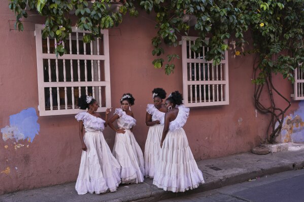 Dancers gather on a sidewalk after performing at a wedding in Cartagena, Colombia, Saturday, May 10, 2025. (AP Photo/Rodrigo Abd)