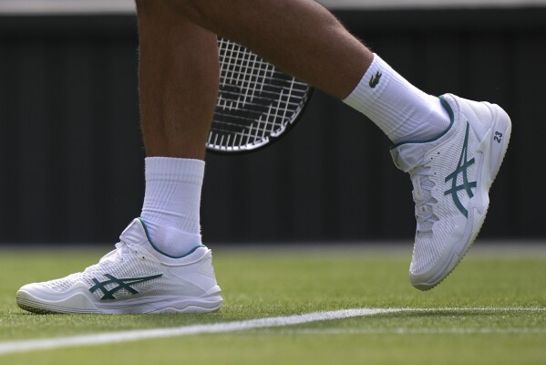 Novak Djokovic plays at Wimbledon with the number '23' printed on his white tennis  shoes | AP News